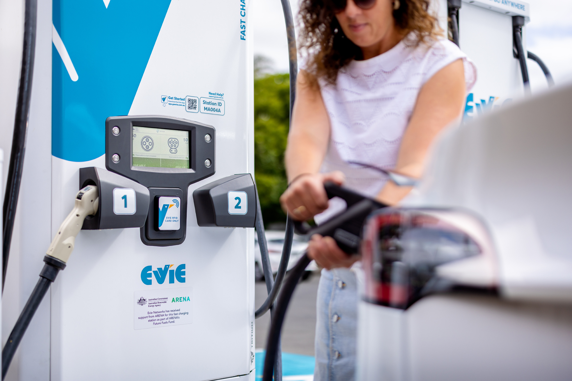 Woman charging car at EV charging station